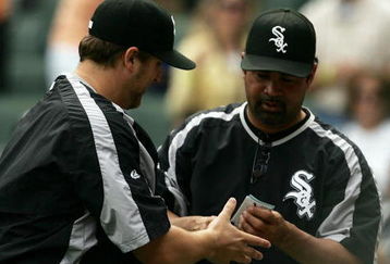 CHICAGO - JUNE 10:  Manager Ozzie Guillen #13 of the Chicago White Sox (R) hands the line-up card to pitcher Mark Buehrle #56 after Buehrle notched his 100th career win against the Houston Astros on June 10, 2007 at U.S. Cellular Field in Chicago, Illinois. The White Sox defeated the Astros 6-3.  (Photo by Jonathan Daniel/Getty Images)