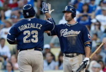 LOS ANGELES, CA - SEPTEMBER 06:  Adrian Gonzalez #23 of the San Diego Padres receives a high five from Kevin Kouzmanoff #5 after hitting a solo homerun in the fifth inning as catcher Russell Martin #55 of the Los Angeles Dodgers looks on at Dodger Stadium on September 6, 2009 in Los Angeles, California. The Padres defeated the Dodgers 4-3.  (Photo by Jeff Gross/Getty Images)