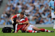 MANCHESTER, ENGLAND - SEPTEMBER 12:  Robin van Persie of Arsenal receives treatment after a challenge from Emmanuel Adebayor of Manchester City during the Barclays Premier League match between Manchester City and Arsenal at the City of Manchester Stadium on September 12, 2009 in Manchester, England.  (Photo by Shaun Botterill/Getty Images)
