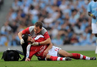 MANCHESTER, ENGLAND - SEPTEMBER 12:  Robin van Persie of Arsenal receives treatment after a challenge from Emmanuel Adebayor of Manchester City during the Barclays Premier League match between Manchester City and Arsenal at the City of Manchester Stadium on September 12, 2009 in Manchester, England.  (Photo by Shaun Botterill/Getty Images)
