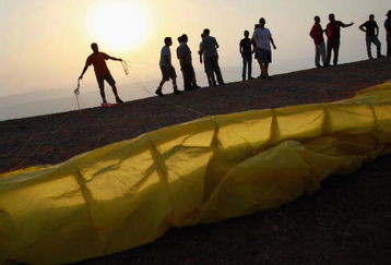 MEVO HAMA, GOLAN HEIGHTS - AUGUST 28:  An Israeli paraglider prepares to take off during the Holy Wind festival on August 28, 2008 on the Mevo Hama cliffs on the Golan Heights. Jerusalem and Damascus may be inching towards peace as they continue to hold indirect talks brokered by Turkey, with Syria demanding a full Israeli withdrawal from the strategic Golan Heights in return for a comprehensive peace.  (Photo by David Silverman/Getty Images)