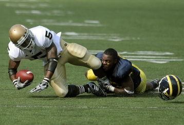 ANN ARBOR, MI - SEPTEMBER 12:  Wide receiver Armando Allen #5 of Notre Dame is tackled by cornerback Donovan Warren #6 of Michigan at Michigan Stadium on September 12, 2009 in Ann Arbor, Michigan.  (Photo by Domenic Centofanti/Getty Images)