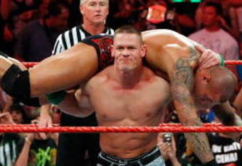 LAS VEGAS - AUGUST 24:  Wrestler John Cena picks up wrestler Randy Orton as wrestler Triple H (R) looks on during the WWE Monday Night Raw show at the Thomas & Mack Center August 24, 2009 in Las Vegas, Nevada.  (Photo by Ethan Miller/Getty Images)