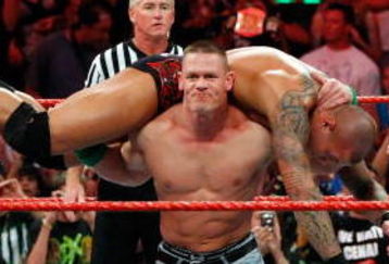 LAS VEGAS - AUGUST 24:  Wrestler John Cena picks up wrestler Randy Orton as wrestler Triple H (R) looks on during the WWE Monday Night Raw show at the Thomas & Mack Center August 24, 2009 in Las Vegas, Nevada.  (Photo by Ethan Miller/Getty Images)