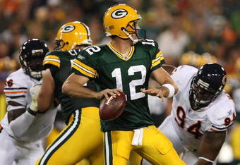 GREEN BAY, WI - SEPTEMBER 13: Aaron Rodgers #12 of the Green Bay Packers looks to pass as Alex Brown #96 and Marcus Harrison #94 of the Chicago Bears rush on September 13, 2009 at Lambeau Field in Green Bay, Wisconsin. (Photo by Jonathan Daniel/Getty Images)