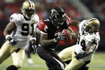 ATLANTA - NOVEMBER 26:  Defensive ends Charles Grant #94 and Will Smith #91 of the New Orleans Saints sack quarterback Michael Vick #7 of the Atlanta Falcons on November 26, 2006 at Georgia Dome in Atlanta, Georgia. The Saints defeated the Falcons 31-13.  (Photo by Doug Benc/Getty Images)