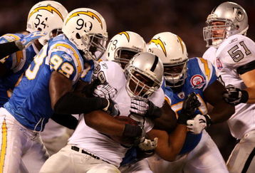 OAKLAND, CA - SEPTEMBER 14: Michael Bush #29 of the Oakland Raiders is tackled by Kevin Burnett #99 the San Diego Chargers along with other CHarger defenders on September 14, 2009 at the Oakland-Alameda County Coliseum in Oakland, California.  (Photo by Ezra Shaw/Getty Images)