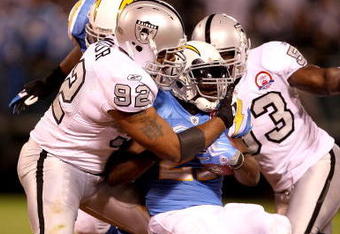 OAKLAND, CA - SEPTEMBER 14:  LaDainian Tomlinson #21 of the San Diego Chargers is tackled by Richard Seymour #92 of the Oakland Raiders during their game on September 14, 2009 at the Oakland-Alameda County Coliseum in Oakland, California.  (Photo by Ezra Shaw/Getty Images)