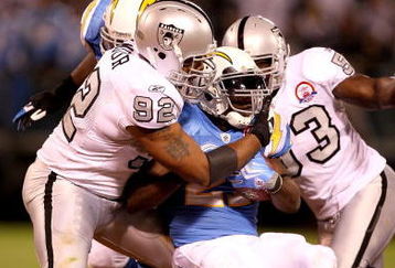 OAKLAND, CA - SEPTEMBER 14:  LaDainian Tomlinson #21 of the San Diego Chargers is tackled by Richard Seymour #92 of the Oakland Raiders during their game on September 14, 2009 at the Oakland-Alameda County Coliseum in Oakland, California.  (Photo by Ezra Shaw/Getty Images)