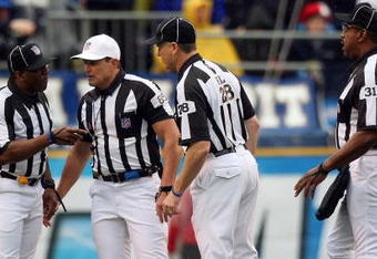 SAN DIEGO - JANUARY 06:  Head Referee Ed Hochuli, wearing the white hat, confers with his colleagues after a play in the first quarter as quarterback Vince Young #10 of the Tennessee Titans rolls on the ground after a defensive play by the San Diego Chargers in the first quarter during their AFC Wild Card Playoff Game at Qualcomm Stadium on January 6, 2008 in San Diego, California.  The Chargers defeated the Titans 17-6. (Photo by Donald Miralle/Getty Images)