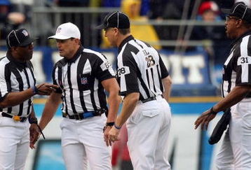 SAN DIEGO - JANUARY 06:  Head Referee Ed Hochuli, wearing the white hat, confers with his colleagues after a play in the first quarter as quarterback Vince Young #10 of the Tennessee Titans rolls on the ground after a defensive play by the San Diego Chargers in the first quarter during their AFC Wild Card Playoff Game at Qualcomm Stadium on January 6, 2008 in San Diego, California.  The Chargers defeated the Titans 17-6. (Photo by Donald Miralle/Getty Images)