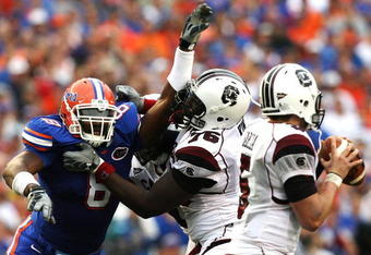 GAINESVILLE, FL - NOVEMBER 15:  Offensive lineman Jarriel King #76 the South Carolina Gamecocks tries to protect his quarterback Stephen Garcia #5 from defensive end Carlos Dunlap #8 of the Florida Gators at Ben Hill Griffin Stadium on November 15, 2008 in Gainesville, Florida.  (Photo by Doug Benc/Getty Images)