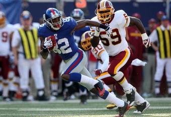 EAST RUTHERFORD, NJ - SEPTEMBER 13:  Mario Manningham #82 of the New York Giants runs the ball past London Fletcher #59 of the Washington Redskins on September 13, 2009 at Giants Stadium in East Rutherford, New Jersey.  (Photo by Jim McIsaac/Getty Images)