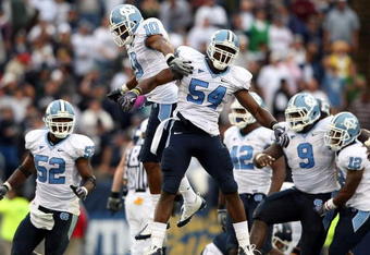 EAST HARTFORD, CT - SEPTEMBER 12:  Bruce Carter #54 of the North Carolinia Tar Heels celebrates his sack with teammates Melvin Williams #10, Marvin Austin #9 and Quan Sturdivant #52 in the final minute of the game against the Connecticut Huskies on September 12, 2009 at Rentschler Field in East Hartford, Connecticut. The Tar Heels defeated the Huskies 12-10.  (Photo by Elsa/Getty Images)