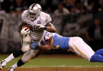 OAKLAND, CA - SEPTEMBER 14:  Darren McFadden #20 of the Oakland Raiders is hit by Clinton Hart #42 of the San Diego Chargers during their game on September 14, 2009 at the Oakland-Alameda County Coliseum in Oakland, California.  (Photo by Ezra Shaw/Getty Images)