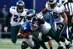EAST RUTHERFORD, NJ - JANUARY 11: Derrick Ward #34 of the New York Giants runs against Trent Cole #58, Akeem Jordan #56 and Quintin Mikell #27 of the Philadelphia Eagles during the NFC Divisional Playoff Game on January 11, 2009 at Giants Stadium in East Rutherford, New Jersey.  (Photo by Chris McGrath/Getty Images)