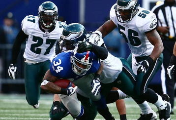 EAST RUTHERFORD, NJ - JANUARY 11: Derrick Ward #34 of the New York Giants runs against Trent Cole #58, Akeem Jordan #56 and Quintin Mikell #27 of the Philadelphia Eagles during the NFC Divisional Playoff Game on January 11, 2009 at Giants Stadium in East Rutherford, New Jersey.  (Photo by Chris McGrath/Getty Images)