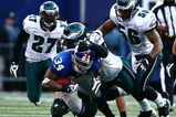 EAST RUTHERFORD, NJ - JANUARY 11: Derrick Ward #34 of the New York Giants runs against Trent Cole #58, Akeem Jordan #56 and Quintin Mikell #27 of the Philadelphia Eagles during the NFC Divisional Playoff Game on January 11, 2009 at Giants Stadium in East Rutherford, New Jersey.  (Photo by Chris McGrath/Getty Images)