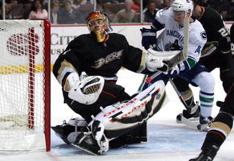 ANAHEIM, CA - MARCH 11:  Goaltender Jonash Hiller #1 of the Anaheim Ducks looks for the puck carrier behind his net as Alex Burrows #14 of the Vancouver Canucks gets into position at the top of the crease area during their NHL game at Honda Center on March 11, 2009 in Anaheim, California. The Ducks defeated the Canucks 4-3 in overtime.  (Photo by Victor Decolongon/Getty Images)
