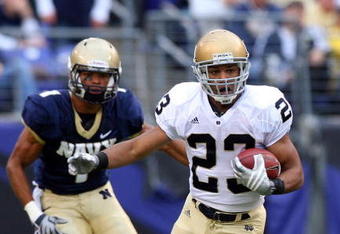 BALTIMORE - NOVEMBER 15:  Golden Tate #23 of the Notre Dame Fighting Irish runs the ball past Blake Carter #1 of the Navy Midshipmen on November 15, 2008 at M&T Bank Stadium in Baltimore, Maryland. Notre Dame defeated Navy 27-21.  (Photo by Jim McIsaac/Getty Images)