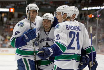 ANAHEIM, CA - SEPTEMBER 17:  (L-R) Travis Ramsey #67, Kyle Wellwood #42 and Mason Raymond #21 of the Vancouver Canucks celebrate a goal by Aaron Rome in the second period against the Anaheim Ducks at the Honda Center on September 17, 2009 in Anaheim, California.  (Photo by Jeff Gross/Getty Images)