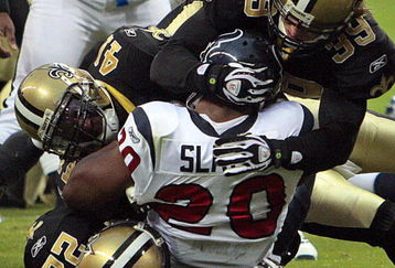 HOUSTON - AUGUST 22:  Running back Steve Slaton #20 of the Houston Texans is tackled by Chris Reis #39, Tracy Porter #22 and Roman Harper #41 of the New Orleans Saints on August 22, 2009 in Houston, Texas.  (Photo by Bob Levey/Getty Images)