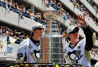 PITTSBURGH - JUNE 15:  Marc-Andre Fleury #29 and Sidney Crosby #87 of the Pittsburgh Penguins show off the Stanley Cup to the crowd on the Blvd of the Allies during the Stanley Cup Champion Victory Parade on June 15, 2009 in Pittsburgh, Pennsylvania.  (Photo by Jamie Sabau/Getty Images)