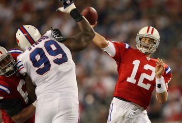 FOXBORO, MA - SEPTEMBER 14:  Tom Brady #12 of the New England Patriots passes the ball as Marcus Stroud #99 of the Buffalo Bills defends on September 14, 2009 at Gillette Stadium in Foxboro, Massachusetts. The Patriots defeated the Bills 25-24.  (Photo by Elsa/Getty Images)