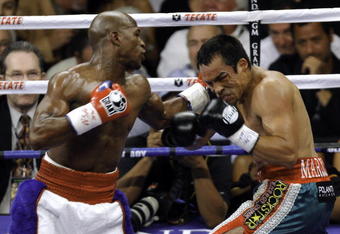 LAS VEGAS - SEPTEMBER 19:  Floyd Mayweather Jr. (L) hits Juan Manuel Marquez during their bout at the MGM Grand Garden Arena September 19, 2009 in Las Vegas, Nevada. Mayweather won by unanimous decision.  (Photo by Eric Jamison/Getty Images)
