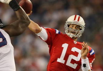 FOXBORO, MA - SEPTEMBER 14:  Tom Brady #12 of the New England Patriots passes the ball as Marcus Stroud #99 of the Buffalo Bills defends on September 14, 2009 at Gillette Stadium in Foxboro, Massachusetts. The Patriots defeated the Bills 25-24.  (Photo by Elsa/Getty Images)