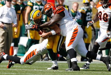 GREEN BAY, WI - SEPTEMBER 20: Quarterback Aaron Rogers #12 of the Green Bay Packers is tackled by defensive tackle Pat Sims #90 of the Cincinnati Bengals at Lambeau Field on September 20, 2009 in Green Bay, Wisconsin. The Bengals defeated the Packers 31-24. (Photo by Scott Boehm/Getty Images)
