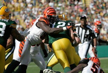 GREEN BAY, WI - SEPTEMBER 20: Quarterback Aaron Rogers #12 of the Green Bay Packers is sacked by defensive end Antwan Odem #98 of the Cincinnati Bengals at Lambeau Field on September 20, 2009 in Green Bay, Wisconsin. The Bengals defeated the Packers 31-24. (Photo by Scott Boehm/Getty Images)