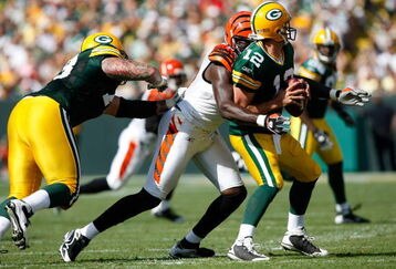 GREEN BAY, WI - SEPTEMBER 20: Quarterback Aaron Rogers #12 of the Green Bay Packers is sacked by defensive end Antwan Odem #98 of the Cincinnati Bengals at Lambeau Field on September 20, 2009 in Green Bay, Wisconsin. The Bengals defeated the Packers 31-24. (Photo by Scott Boehm/Getty Images)