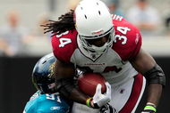 JACKSONVILLE, FL - SEPTEMBER 20:  Tim Hightower #34 of the Arizona Cardinals is tackled by Derrick Harvey #91 of the Jacksonville Jaguars during the game at Jacksonville Municipal Stadium on September 20, 2009 in Jacksonville, Florida.  (Photo by Sam Greenwood/Getty Images)