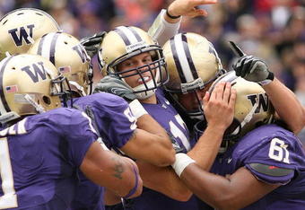 SEATTLE - SEPTEMBER 19:  Quarterback Jake Locker #10 of the Washington Huskies is mobbed by teammates after scoring a touchdown against the USC Trojans on September 19, 2009 at Husky Stadium in Seattle, Washington. The Huskies defeated the Trojans 16-13. (Photo by Otto Greule Jr/Getty Images)
