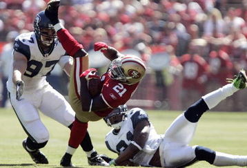 SAN FRANCISCO - SEPTEMBER 20:  Running back Frank Gore #21 of the San Francisco 49ers breaks a tackle by cornerback Ken Lucas #31 and defensive end Patrick Kerney of the Seattle Seahawks in the first quarter during the home opener at Candlestick Park on September 20, 2009 in San Francisco, California.  (Photo by David Paul Morris/Getty Images)