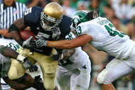 SOUTH BEND, IN - SEPTEMBER 19: Armando Allen #5 of the Notre Dame Fighting Irish is tackled by Greg Jones #53, Trevor Anderson #58 and Eric Gordon #43 of the Michigan State Spartans on September 19, 2009 at Notre Dame Stadium in South Bend, Indiana. Notre Dame defeated Michigan State 33-30. (Photo by Jonathan Daniel/Getty Images)