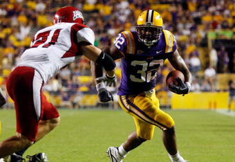 BATON ROUGE, LA - SEPTEMBER 19:  Charles Scott #32 of the Louisiana State University Tigers tries to avoid a tackle by Trace Wilson #71 of the University of Louisiana-Lafatette Ragin' Cajuns at Tiger Stadium on September 19, 2009 in Baton Rouge, Louisiana.  The Tigers defeated the Cajuns 31-3.  (Photo by Chris Graythen/Getty Images)