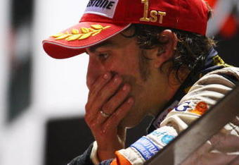 SINGAPORE - SEPTEMBER 28:  Fernando Alonso of Spain and Renault celebrates on the podium after winning the Singapore Formula One Grand Prix at the Marina Bay Street Circuit on September 28, 2008 in Singapore.  The event is the first Formula One race to be held at night.  (Photo by Clive Mason/Getty Images)