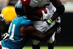 JACKSONVILLE, FL - SEPTEMBER 20:  Tim Hightower #34 of the Arizona Cardinals is tackled by Derrick Harvey #91 of the Jacksonville Jaguars during the game at Jacksonville Municipal Stadium on September 20, 2009 in Jacksonville, Florida.  (Photo by Sam Greenwood/Getty Images)