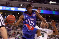 INDIANAPOLIS - MARCH 27:  Tyshawn Taylor #15 of the Kansas Jayhawks looks to pass the ball in midair against Durrell Summers #15 of the Michigan State Spartans during the third round of the NCAA Division I Men's Basketball Tournament at the Lucas Oil Stadium on March 27, 2009 in Indianapolis, Indiana.  (Photo by Andy Lyons/Getty Images)
