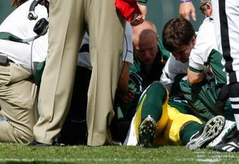 GREEN BAY, WI - SEPTEMBER 20: Defensive back Nick Collins #36 of the Green Bay Packers is attended to by trainers as he lays on the field after an injury as head coach Mike McCarthy looks on against the Cincinnati Bengals at Lambeau Field on September 20, 2009 in Green Bay, Wisconsin. The Bengals defeated the Packers 31-24. (Photo by Scott Boehm/Getty Images)