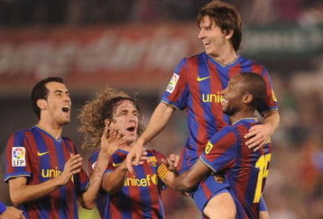 SANTANDER, SPAIN - SEPTEMBER 22:  Lionel Messi of Barcelona is lifted up by Seydou Keita after scoring Barcelona's fourth goal against Racing Santander during the La Liga match between Racing Santander and Barcelona at El Sardinero stadium on September 22, 2009 in Santander, Spain.  (Photo by Denis Doyle/Getty Images)