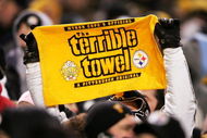 PITTSBURGH - JANUARY 23:  A fan holds up a 'terrible towel' as the New England Patriots take on the Pittsburgh Steelers in the AFC championship game at Heinz Field on January 23, 2005 in Pittsburgh, Pennsylvania. The Patriots defeated the Steelers 41-27. (Photo by Andy Lyons/Getty Images)