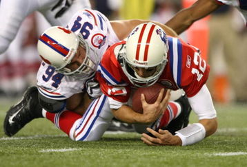 FOXBORO, MA - SEPTEMBER 14:  Quarterback Tom Brady #12 of the New England Patriots is sacked by Aaron Schobel #94 of the Buffalo Bills on September 14, 2009 at Gillette Stadium in Foxboro, Massachusetts. (Photo by Elsa/Getty Images)