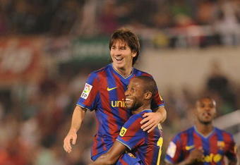 SANTANDER, SPAIN - SEPTEMBER 22:  Lionel Messi of Barcelona is lifted up by teammate Seydou Keita after scoring the 4:0 goal against Racing Santander during the La Liga match between Racing Santander and Barcelona at El Sardinero stadium on September 22, 2009 in Santander, Spain.  (Photo by Denis Doyle/Getty Images)