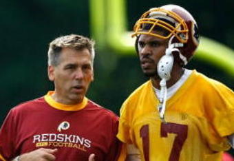 ASHBURN, VA - JULY 30:  Washington Redskins Head Coach Jim Zorn (C) talks with quarterback Jason Campbell (#17) during opening day of training camp July 30, 2009 in Ashburn, Virginia.  (Photo by Win McNamee/Getty Images)