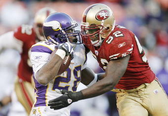 SAN FRANCISCO - DECEMBER 9:  Running back Adrian Peterson #28 of the Minnesota Vikings is hit by linerbacker Patrick Willis #52 of the San Francisco 49ers during a game on December 9, 2007 at Monster Park in San Francisco, California. Minnesota won 27-7.  (Photo by Greg Trott/Getty Images)
