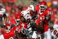 PISCATAWAY, NJ - SEPTEMBER 29: Jason McCourty #25 and Ron Girault #43 of the Rutgers Scarlet Knights tackle Da'Rel Scott #23 of the Maryland Terrapins during their game at Rutgers Stadium on September 29, 2007 in Piscataway, New Jersey. (Photo by Nick Laham/Getty Images)