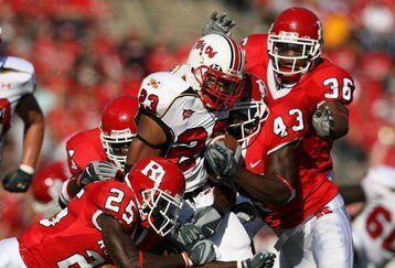PISCATAWAY, NJ - SEPTEMBER 29: Jason McCourty #25 and Ron Girault #43 of the Rutgers Scarlet Knights tackle Da'Rel Scott #23 of the Maryland Terrapins during their game at Rutgers Stadium on September 29, 2007 in Piscataway, New Jersey. (Photo by Nick Laham/Getty Images)